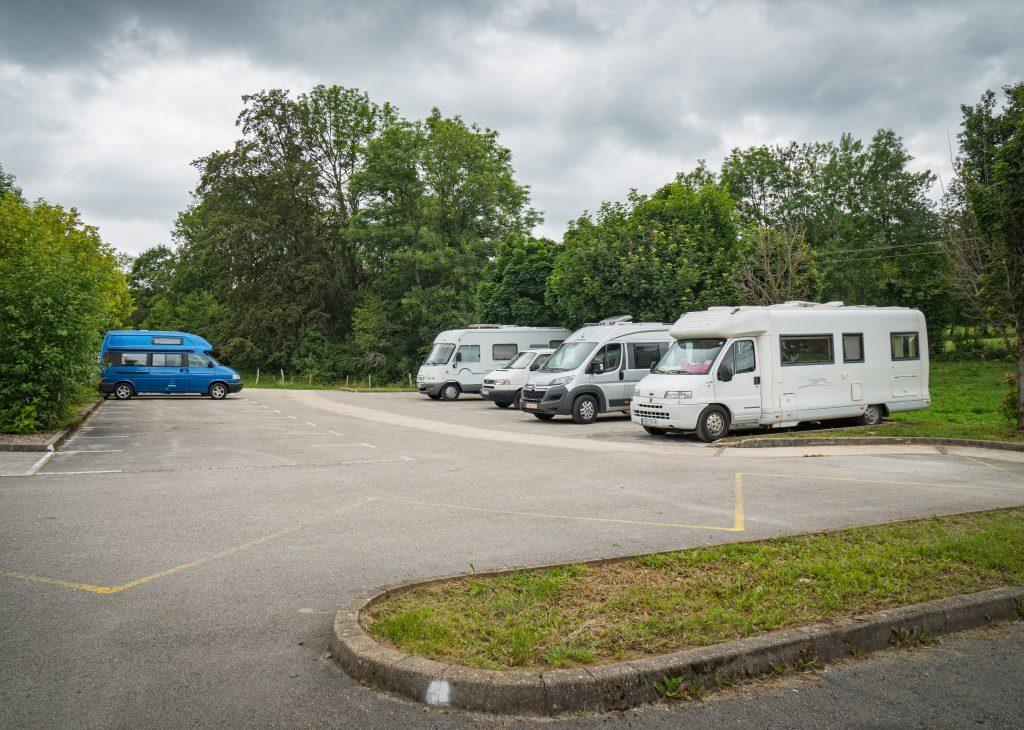 parkplaetze-wasserfall-doubs-wandern-jura Fünf Campers auf Parkplatz des Wasserfall Doubs, bewölkter Himmel - Wandern Jura